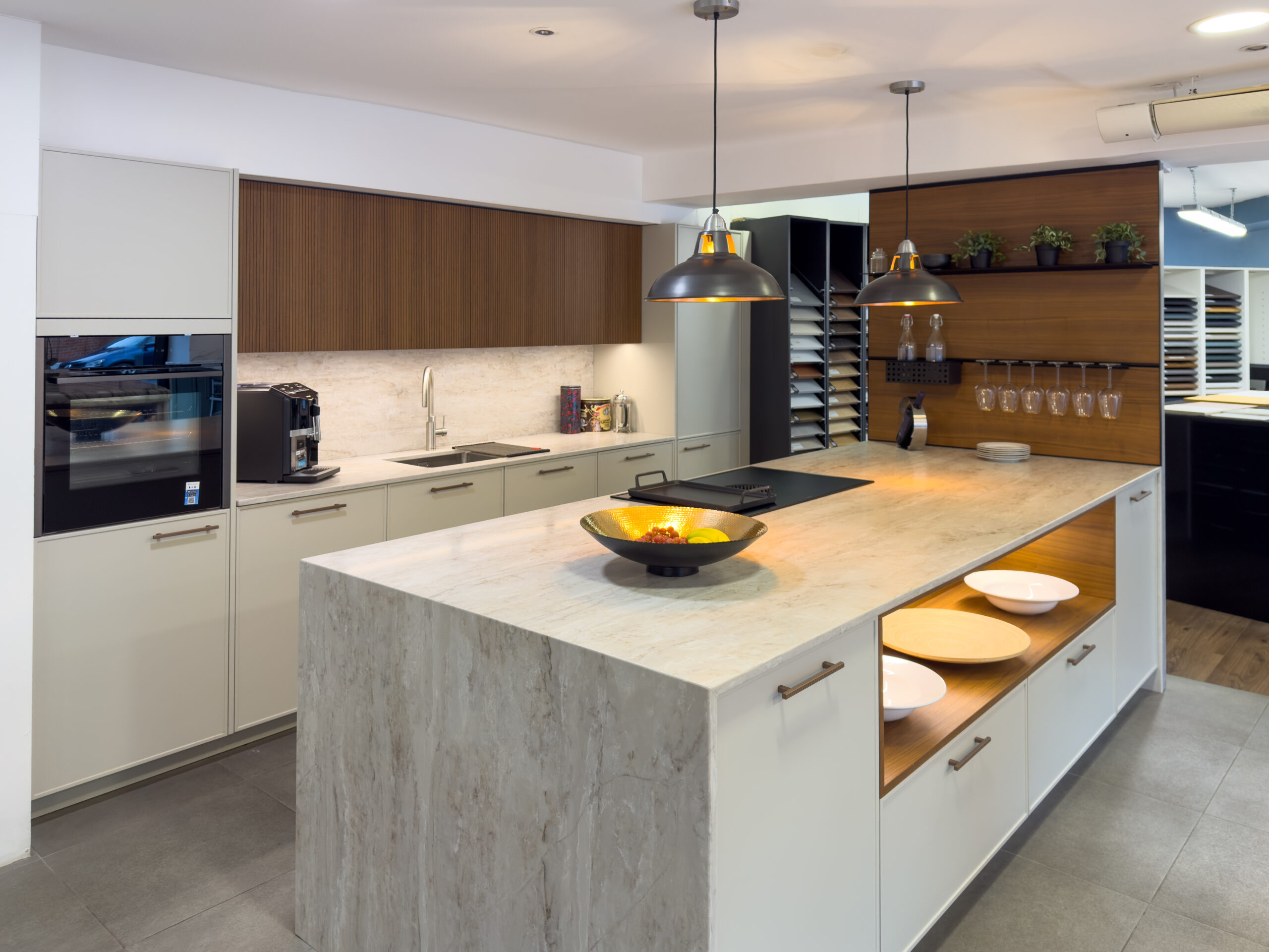 contemporary kitchen with wood veneer cabinets and marble island, modern kitchen showroom with mixed cabinet finishes, luxury kitchen with warm timber accents